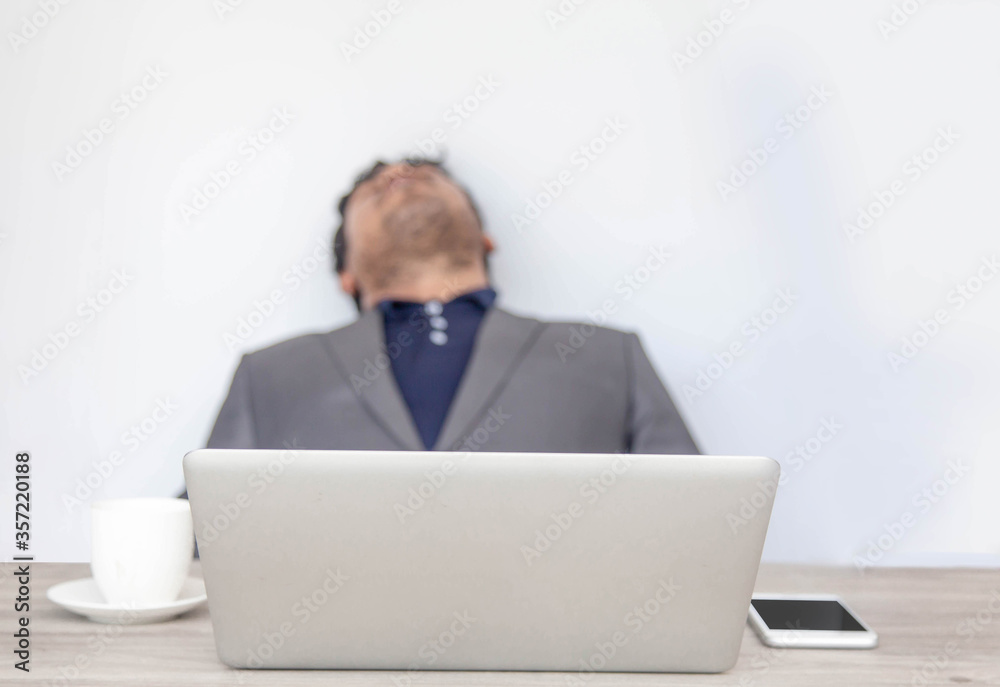 Businessman tired overworked sleeping on office desk.