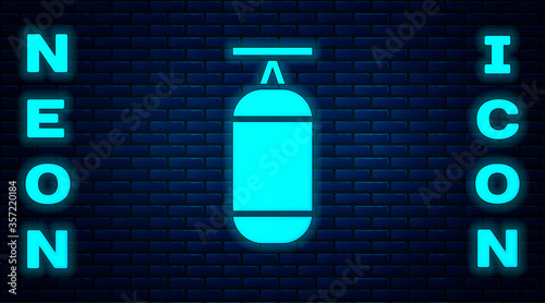 Glowing neon Punching bag icon isolated on brick wall background. Vector Illustration.