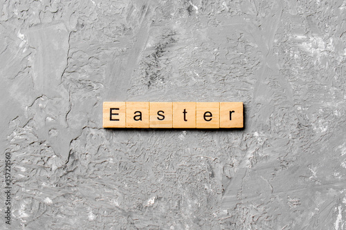 Easter word written on wood block. Easter text on cement table for your desing, concept