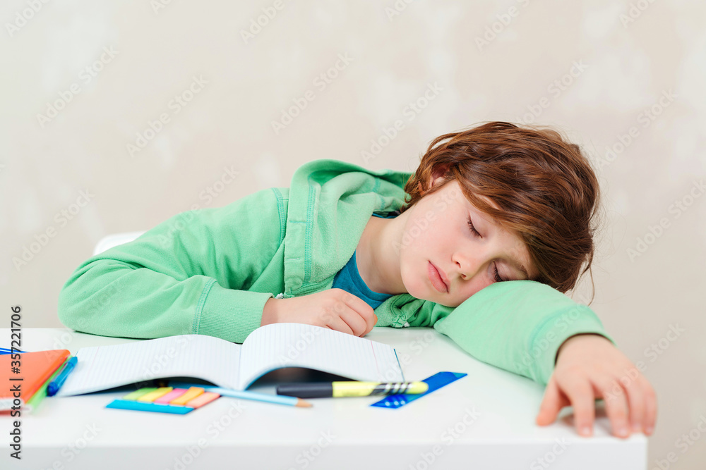 Tired schoolboy sleep at the table during homework. Studying difficulties, education, homework concept. ld. Tired schoolboy sleep at the table during homework. Studying difficulties, education, homework concept. ld.