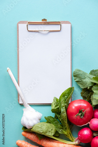Small whiteboard with vegetables around. Copy space