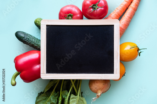 Small blackboard with vegetables around. Healthy concept with copy space
