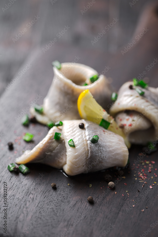 Naklejka premium classic marinated herring rolls with chives and lemon