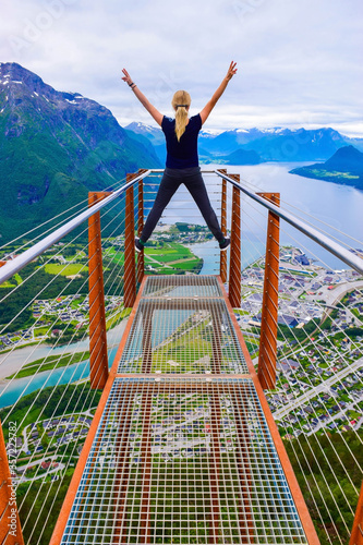 Hiking Rampestreken. Tourist girl on the Rampestreken Viewpoin. Panoramic landscape Andalsnes city in  Norway. photo