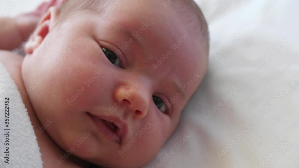 closeup Authentic portrait of newborn baby face eyes looking closeup Authentic portrait of newborn baby face eyes looking