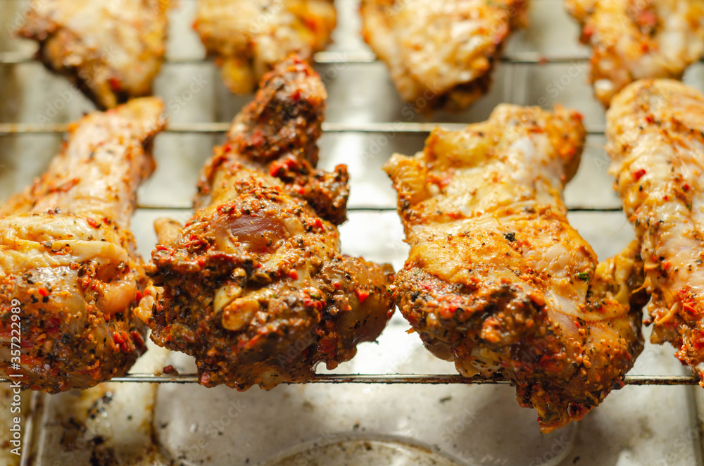 Raw chicken wings with a rendang style rub made with chilli and garlic on the grill tray
