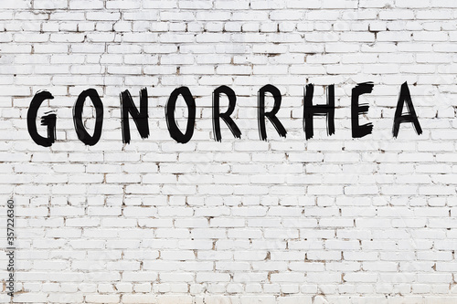 Fotografie Word gonorrhea painted on white brick wall