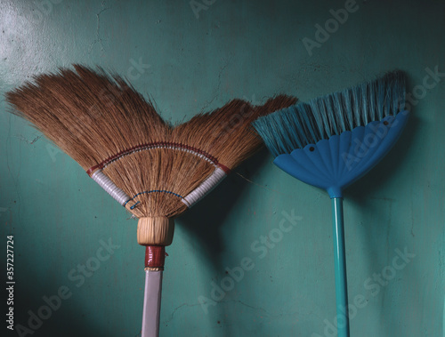 A traditional Filipino broom versus modern broom closely captured. photo