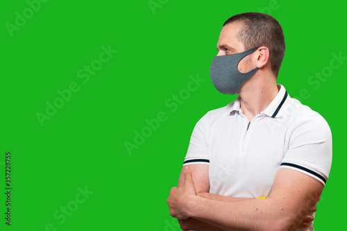 Man in face medical mask at green background