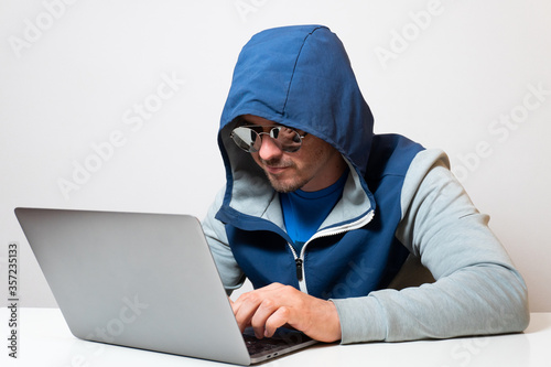 Hacker or developer in blue hoodie coding