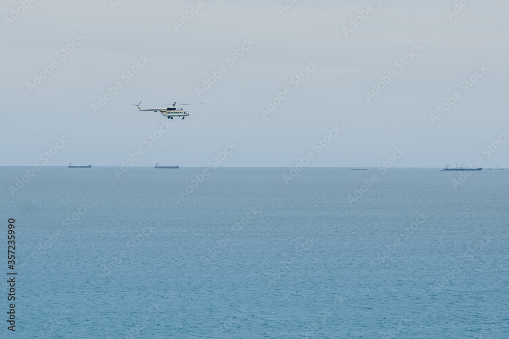 helicopter flies above the sea helicopter flies above the sea