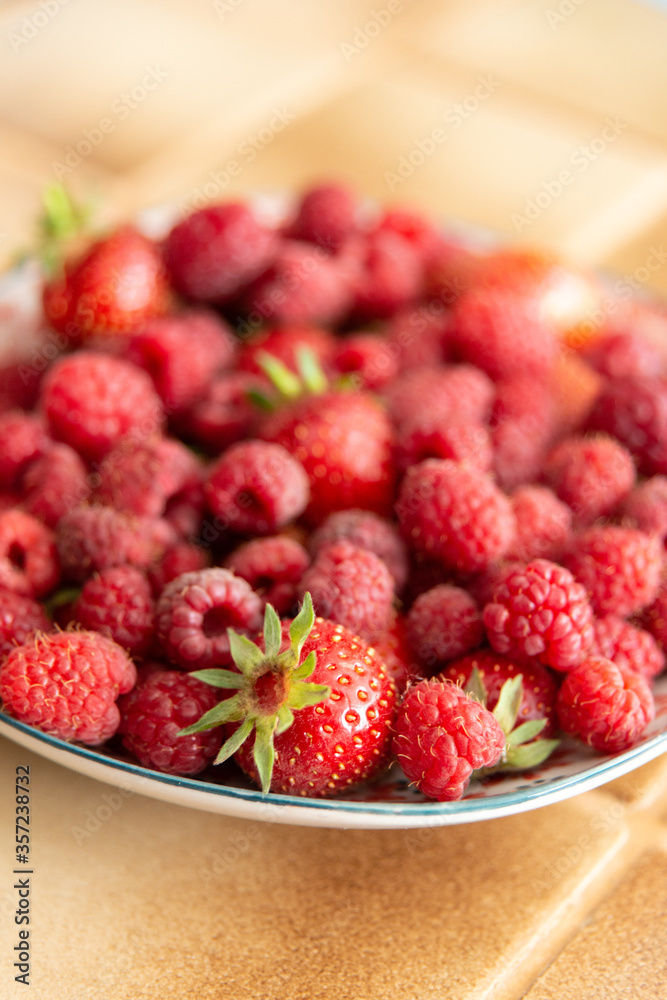 Assiette de fraises et de framboises fraîches dans une cuisine Assiette de fraises et de framboises fraîches dans une cuisine