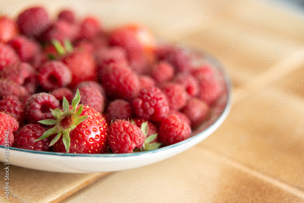 Assiette de fraises et de framboises fraîches dans une cuisine Assiette de fraises et de framboises fraîches dans une cuisine