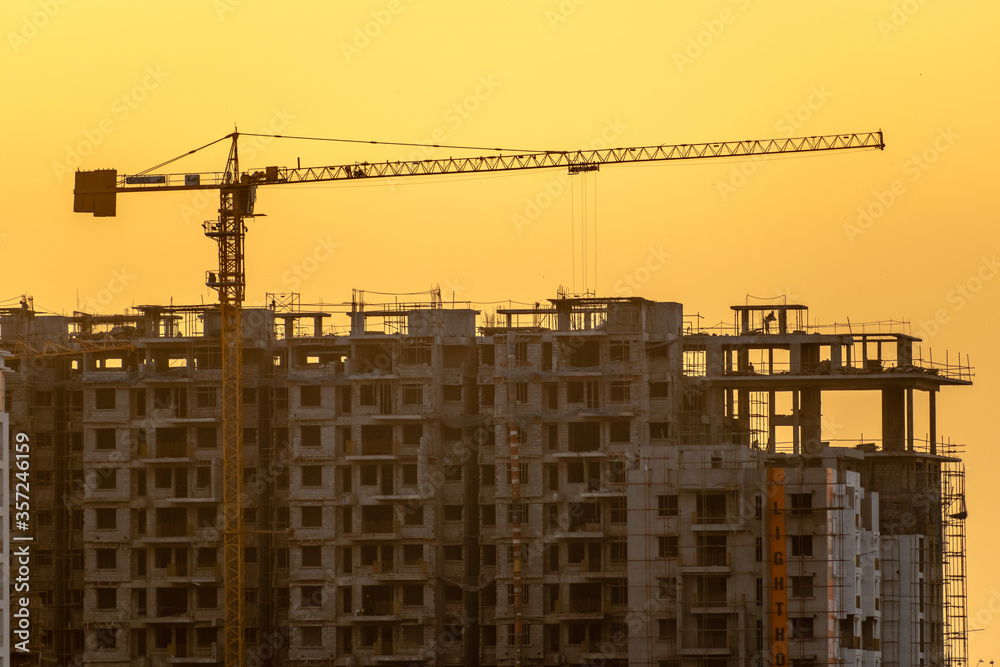 A highrise building under construction during golden hour