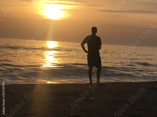 man walking on the beach at sunset