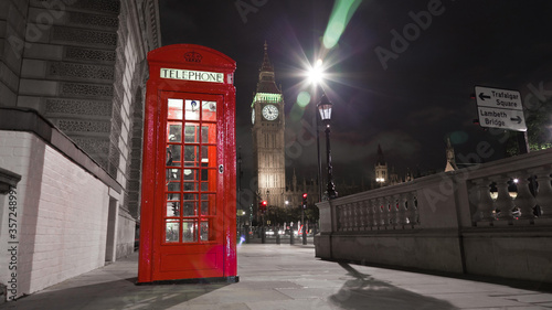 View of Big Ben behind a red telephone booth in London at night. © Stock Footage, Inc.