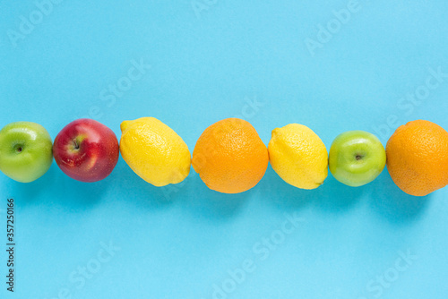Fototapeta Naklejka Na Ścianę i Meble -  top view of ripe fruits in line on blue background