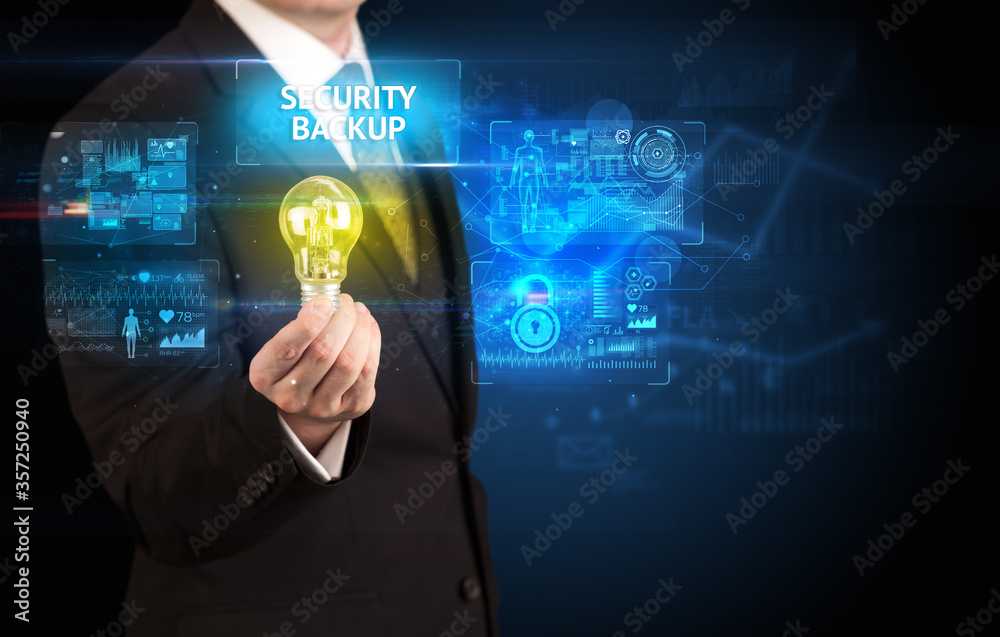 Businessman holding lightbulb with SECURITY BACKUP inscription, online security idea concept Businessman holding lightbulb with SECURITY BACKUP inscription, online security idea concept