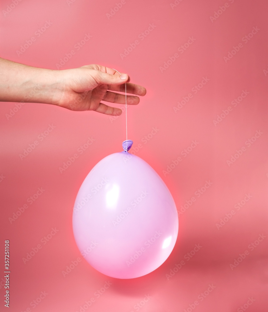 Fototapeta premium The guy holds a balloon in his hand. Childhood.