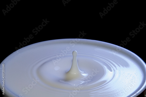 Milk drop falling on a cup full of milk
