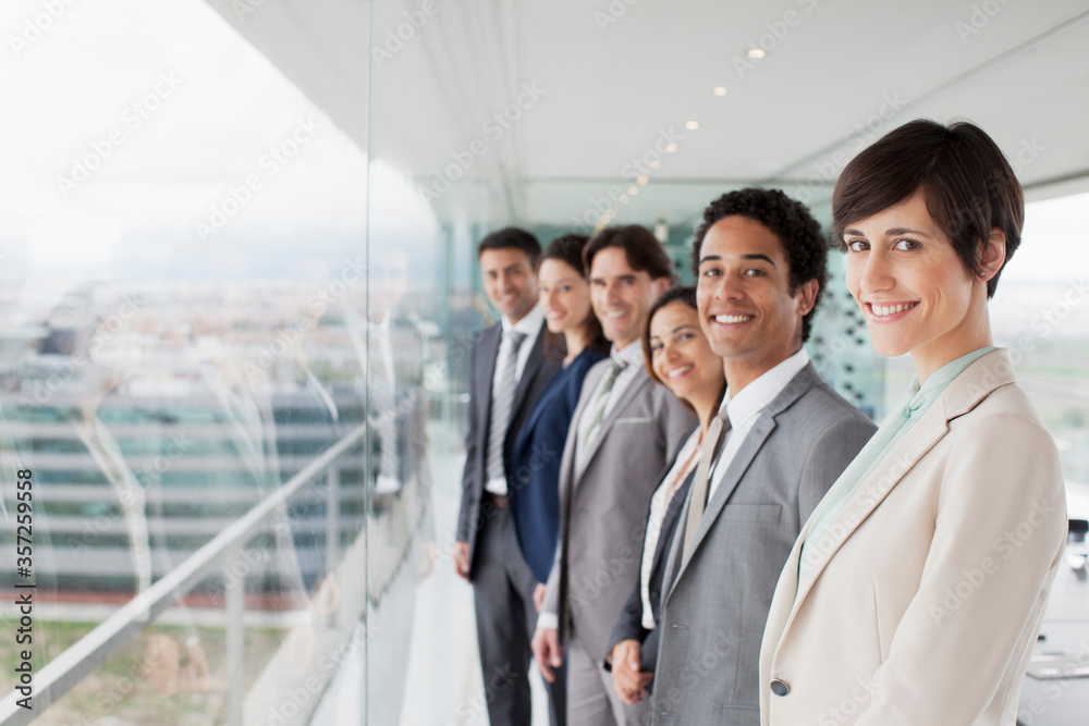 Obraz premium Portrait of smiling business people at window in conference room