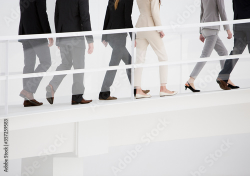 Business people ascending elevated walkway photo