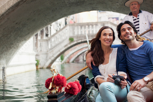Smiling couple riding in gondola in Venice