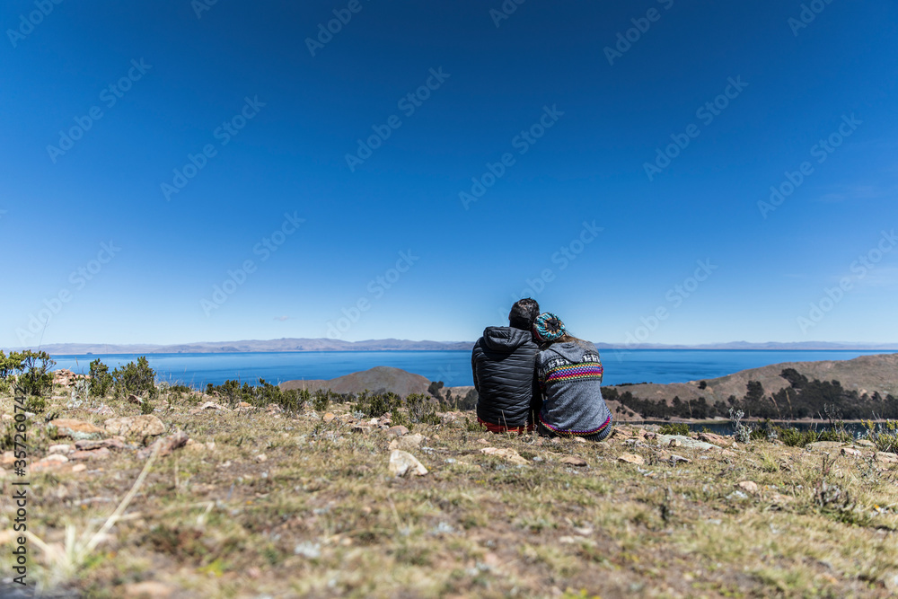 Fototapeta premium Couple sitting together by a huge lake