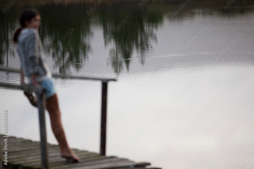 Woman standing on dock over lake Woman standing on dock over lake