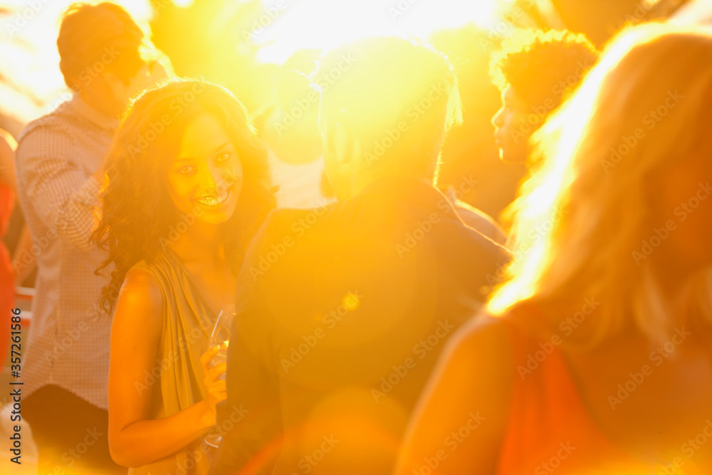 Spotlight behind couples dancing on dance floor