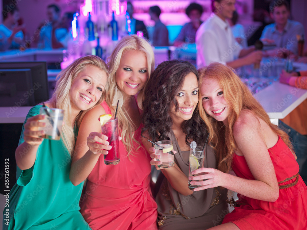 Portrait of smiling women with cocktails in nightclub