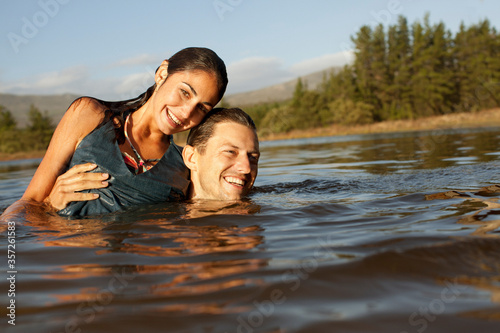 Portrait of smiling couple swimming in lake