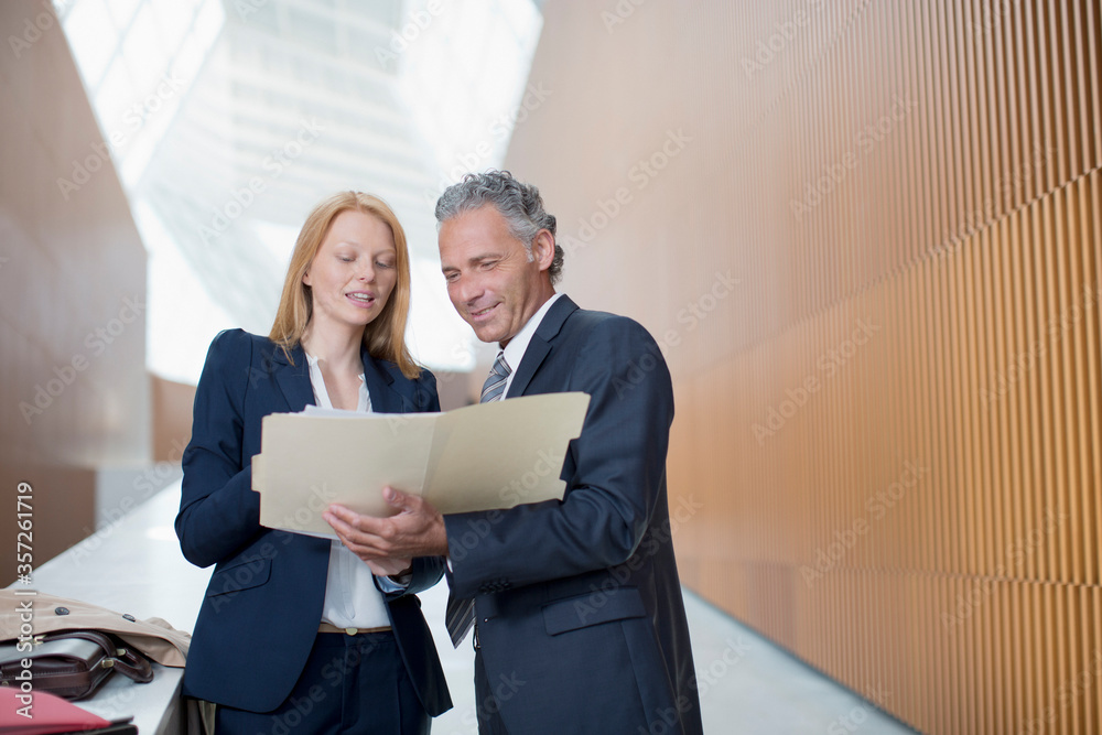 Businessman and businesswoman reviewing paperwork Businessman and businesswoman reviewing paperwork