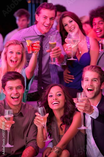 Portrait of smiling friends drinking cocktails in nightclub