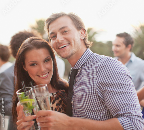 Close up portrait of smiling couple drinking cocktails
