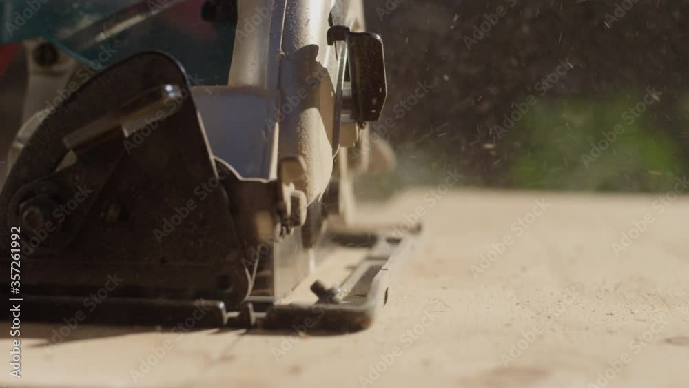 Extreme close-up on a circular saw cutting a piece of wood in slow motion