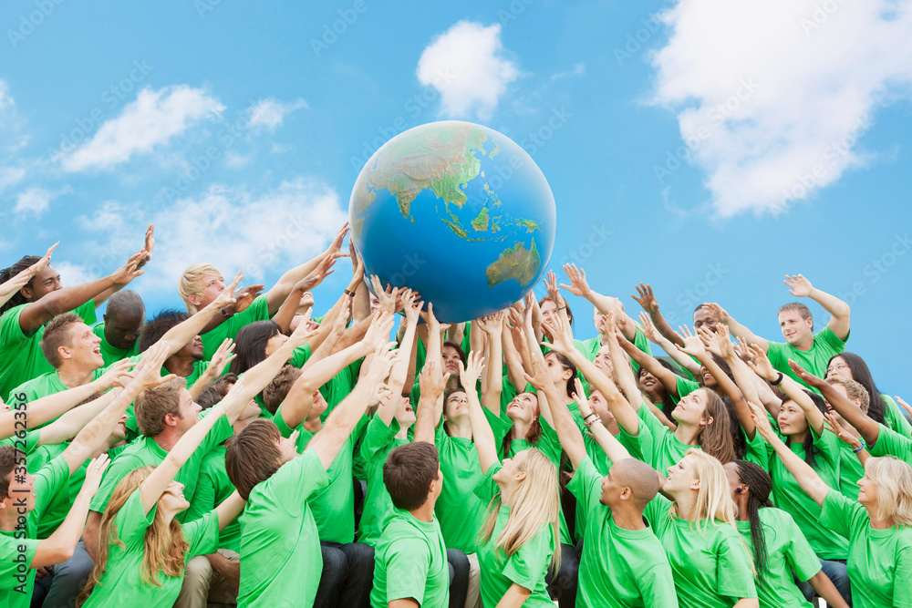 © Rob Daly/KOTO - Team in green t-shirts lifting globe overhead © Rob Daly/KOTO - Team in green t-shirts lifting globe overhead