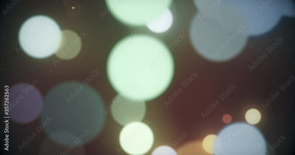 Colorful defocused particles bokeh with a blurred depth of field. Multi-colored bokeh moving floating particle animation. Seamless Loop.