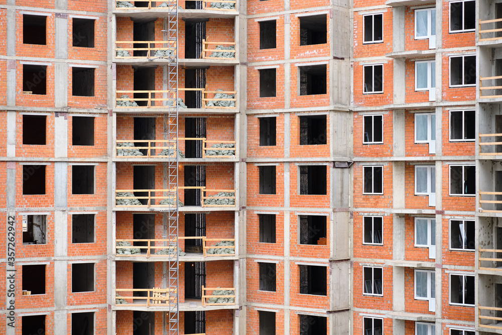 Windowless high-rise brick house under construction.