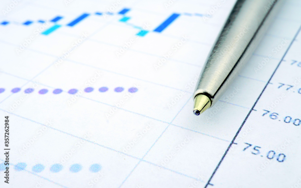 Trading chart and pen on a sheet of paper. Stock quotes in the form of a graph. Business project on paper. Profitable shares. Profit from financial activities. Risky business. Trading chart and pen on a sheet of paper. Stock quotes in the form of a graph. Business project on paper. Profitable shares. Profit from financial activities. Risky business.