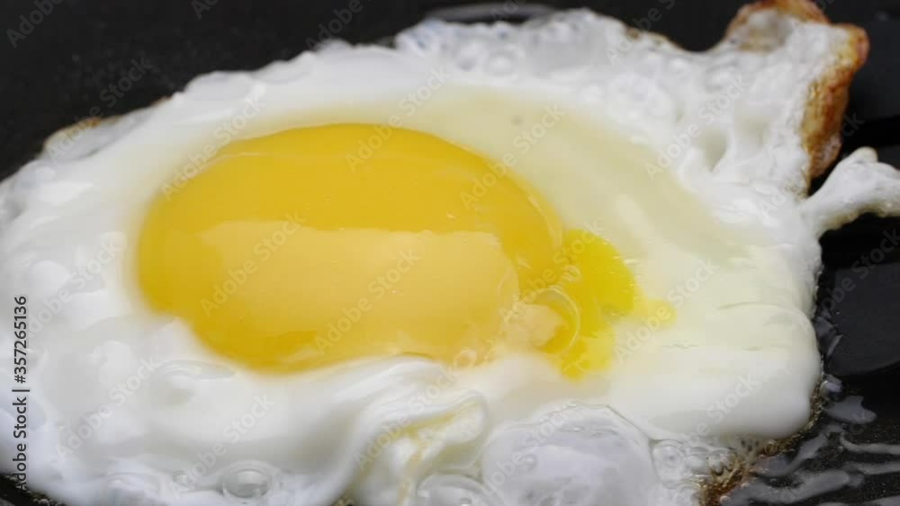 Fried eggs in a pan for breakfast. Slow-motion. Close up. Fried eggs in a pan for breakfast. Slow-motion. Close up.