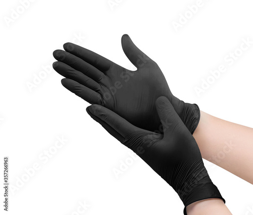 Two black surgical medical gloves isolated on white background with hands. Rubber glove manufacturing, human hand is wearing a latex glove. Doctor or nurse putting on nitrile protective gloves