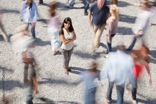 Photography Portrait of confident woman standing among rushing crowd