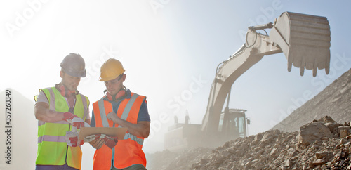 Workers reading blueprints in quarry