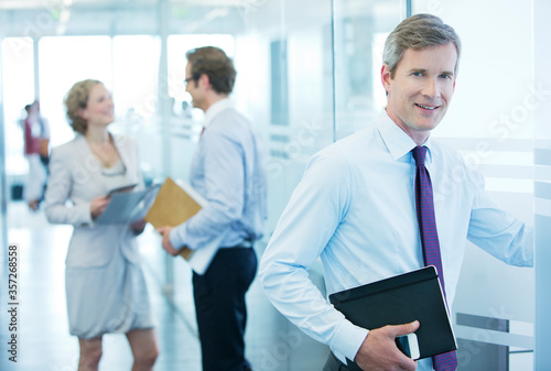 Businessman smiling in office hallway