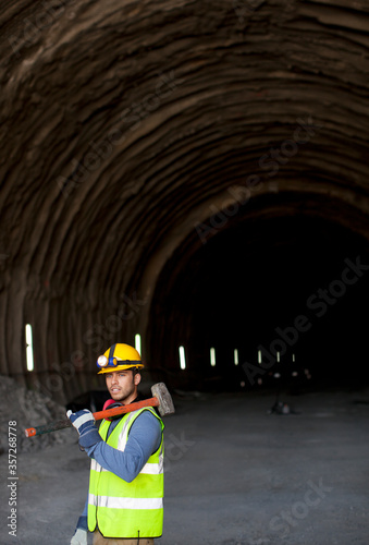 Worker holding sledgehammer in tunnel