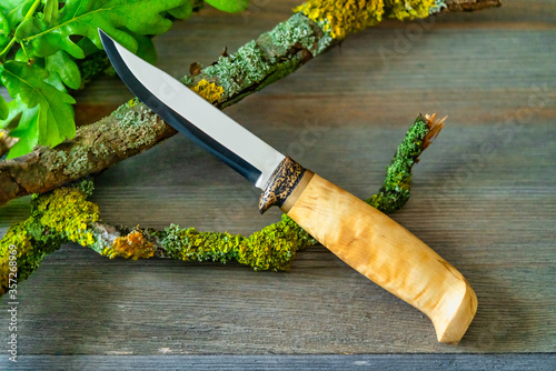 hunting knife lies on wooden table photo