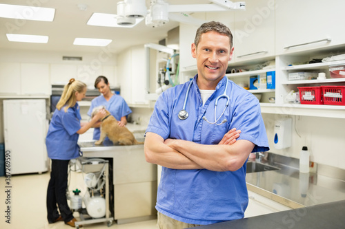 Smiling veterinarian standing in vet       s surgery