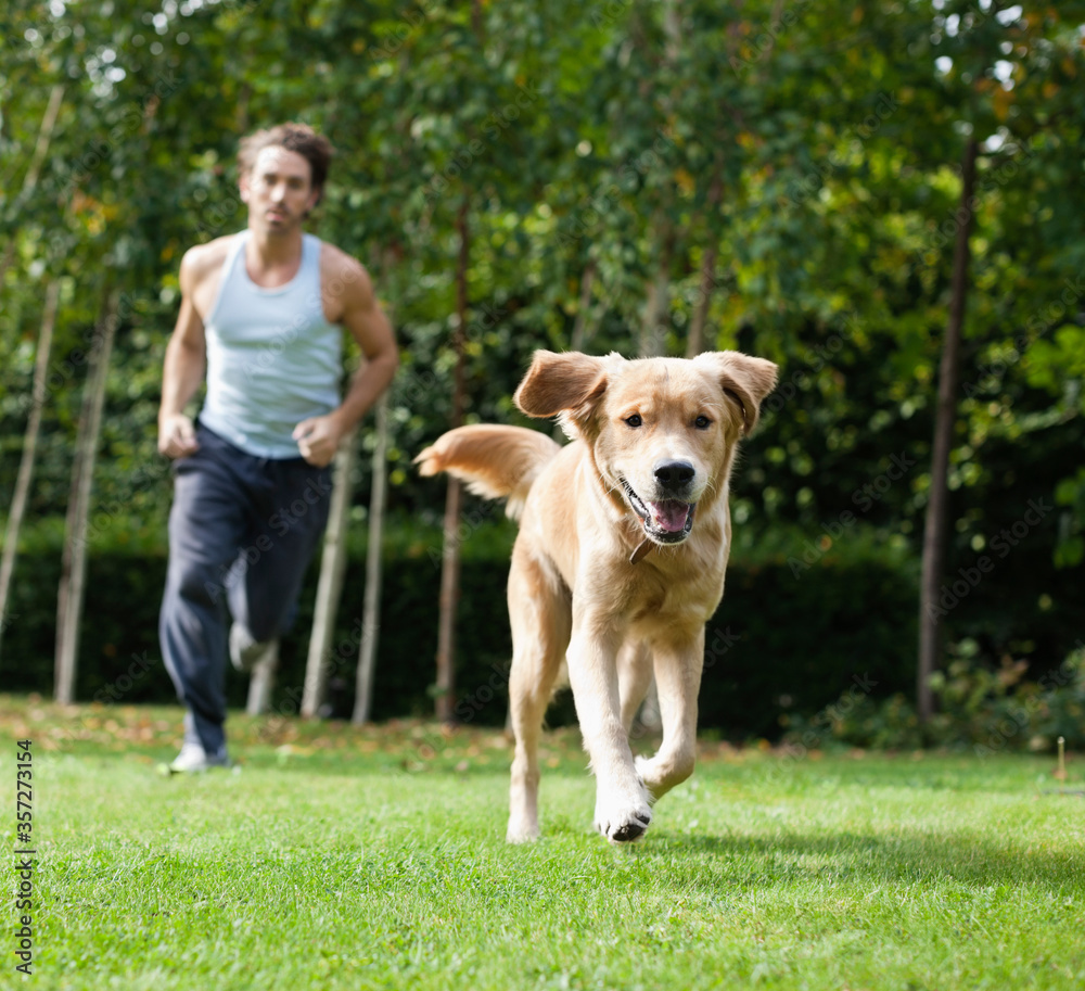 Man running with dog in park Man running with dog in park