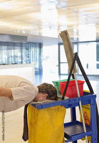 Businessman putting face in trash bag